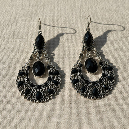 Amare Tutto bohemian chandelier earrings in antiqued silver with black faceted stones and intricate filigree detail.