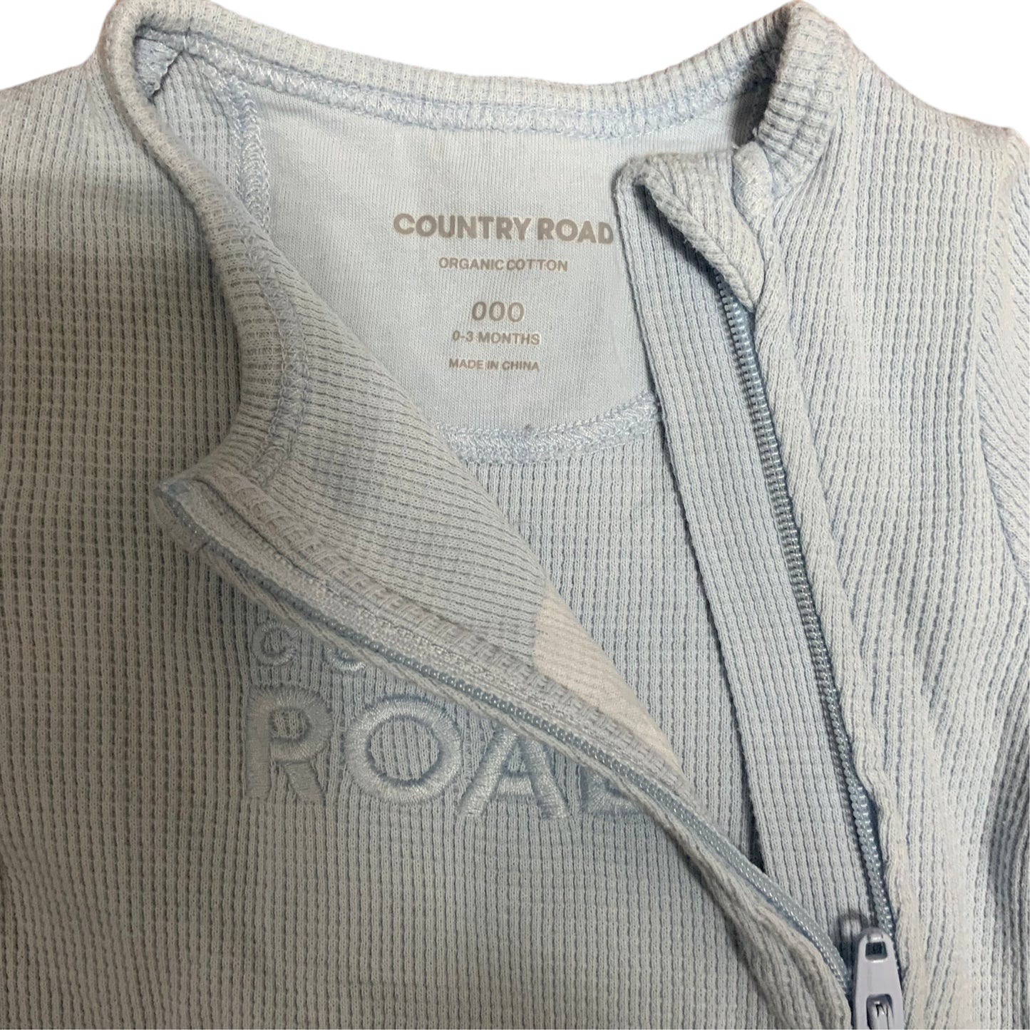 Amare Tutto Country Road light blue organic cotton waffle knit baby one piece with front zipper closure