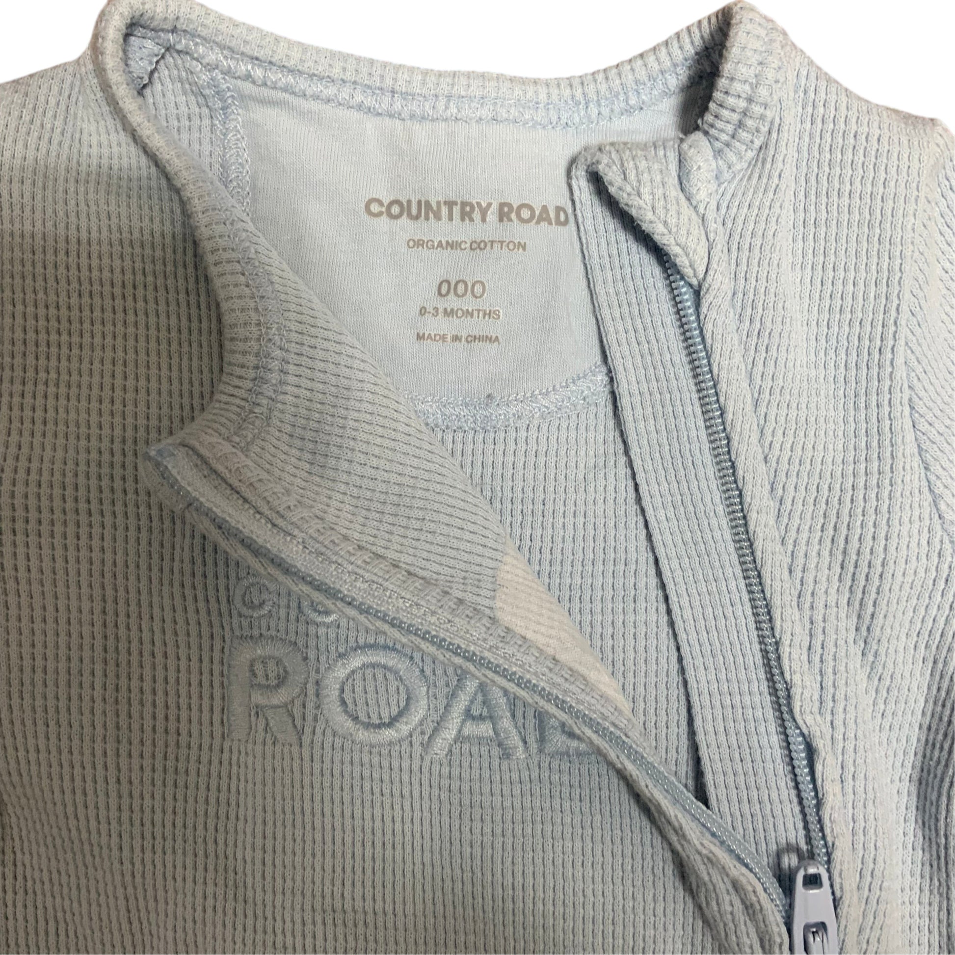 Amare Tutto Country Road light blue organic cotton waffle knit baby one piece with front zipper closure